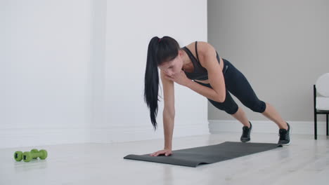 a-girl-is-doing-exercises-on-a-mat-at-home-without-dumbbells
